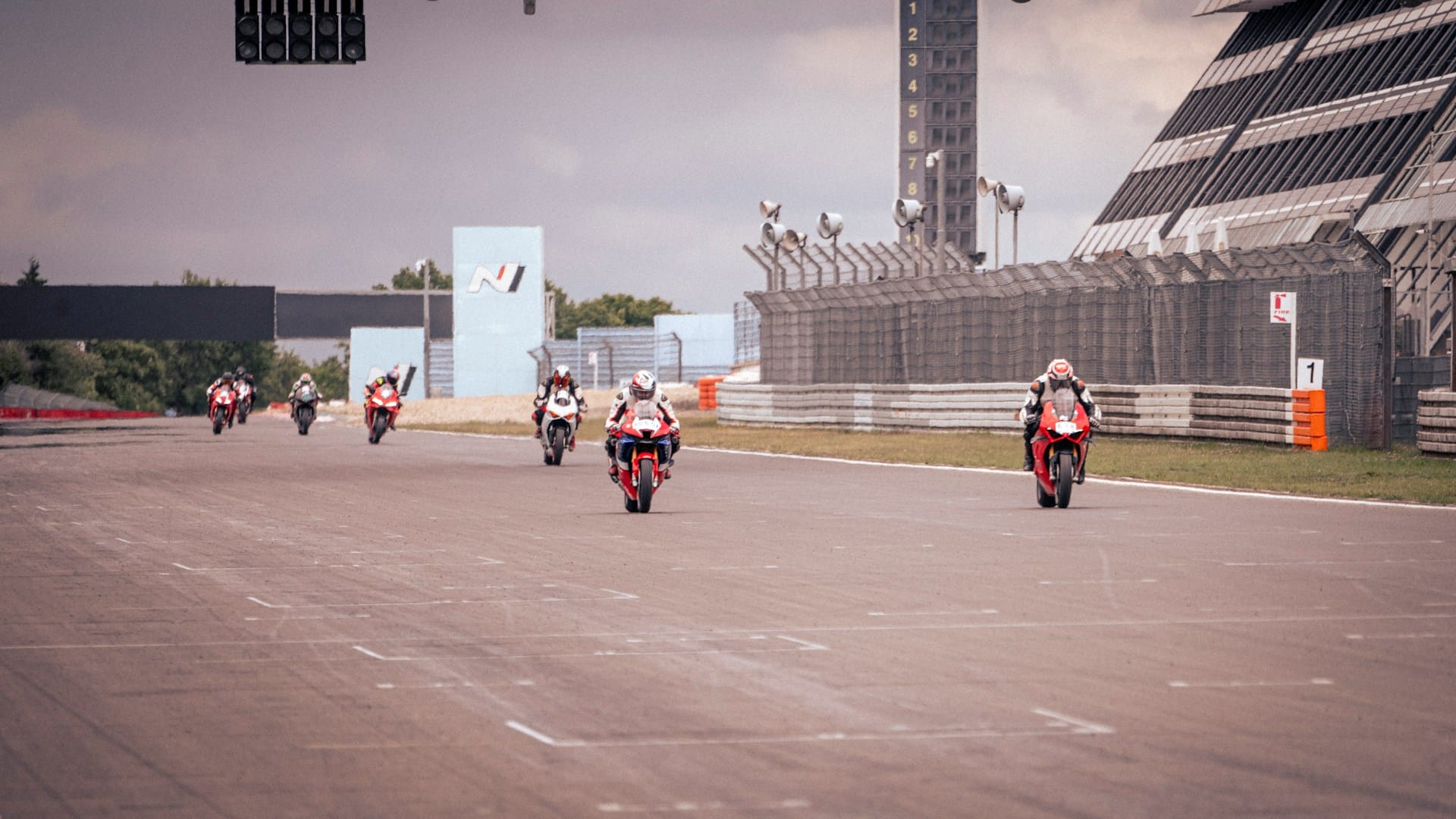 Multiple superbikes racing in close competition on a circuit track
