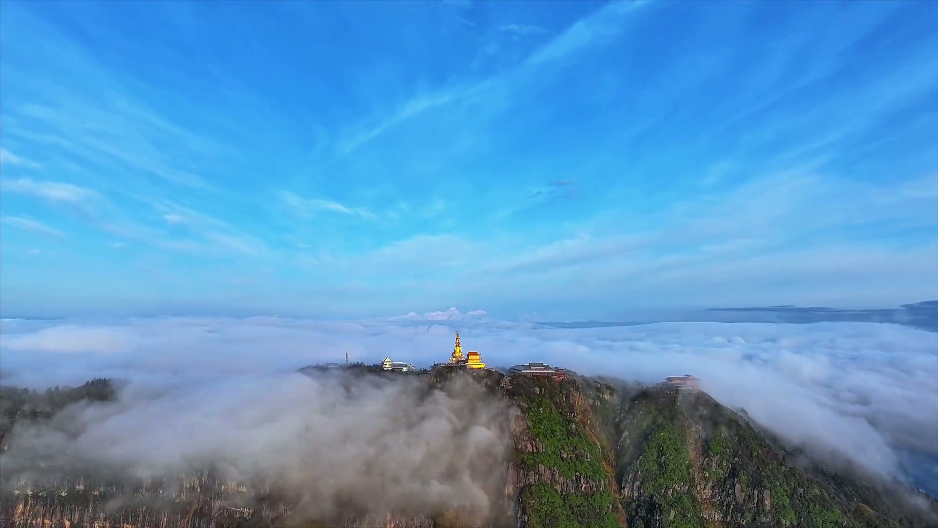 Golden Buddha statue at Mount Emei Golden Summit at sunrise, towering above sea of clouds in Sichuan, China.