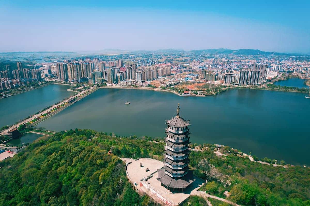 Aerial view of a historic pagoda overlooking a lake and modern city skyline in Jiangxi Province, China