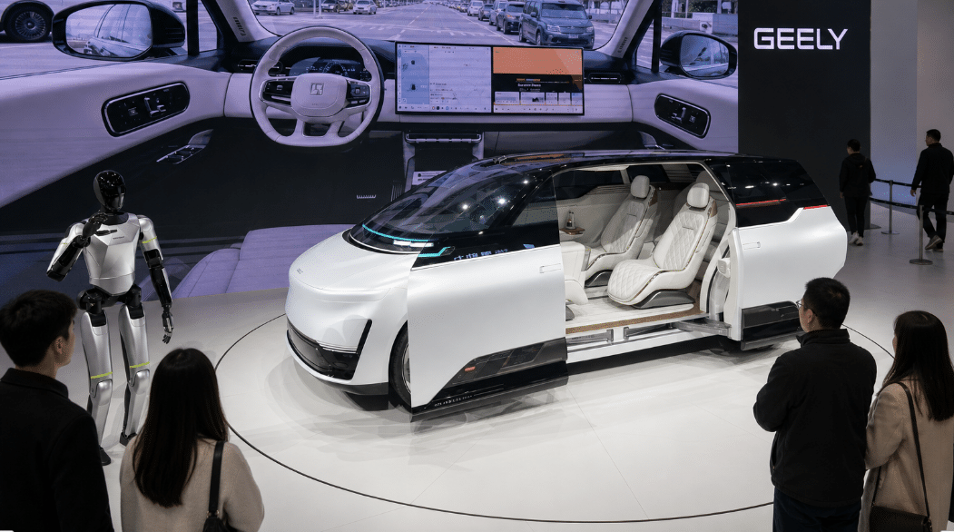 Futuristic electric concept car with open sliding doors displayed at an auto show alongside a humanoid robot and digital dashboard screen